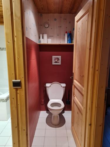 - des toilettes dans une salle de bains aux murs rouges dans l'établissement Chez Pépino, à Lanslebourg-Mont-Cenis