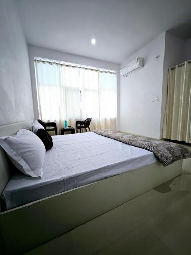 a large bed in a room with a large window at Nikunj Mahal Homestay in Udaipur