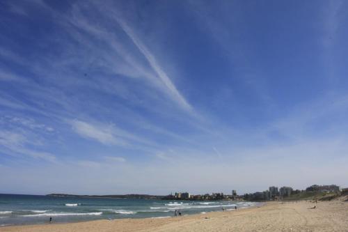 a beach with a blue sky and the ocean at U1 - Quaint 1 Bedroom Unit, Wanda Beach in Cronulla