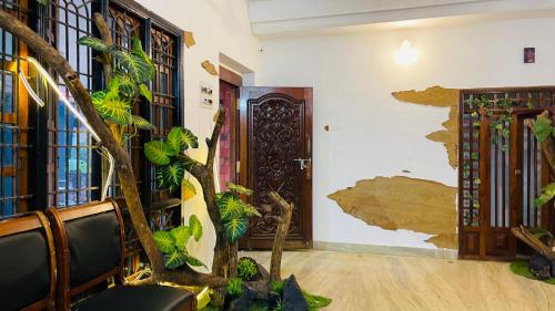 una habitación con un árbol y una pared con una puerta en Boho Beach House, en Malpe