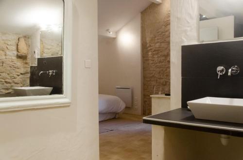 ein Badezimmer mit Waschbecken und ein Bett in einem Zimmer in der Unterkunft La Ruelle au Verjus in Sancé