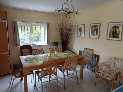 una sala da pranzo con tavolo e sedie di Cosy garden house in a villa a Palaia Fokaia