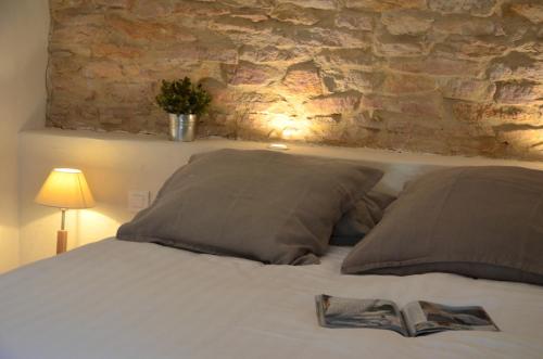 ein Bett mit zwei Kissen und ein Buch darauf in der Unterkunft La Ruelle au Verjus in Sancé