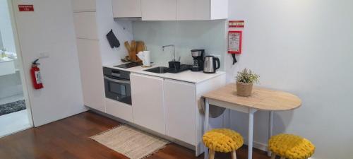 una pequeña cocina blanca con mesa y fogones en Ria Palace Apartment, en Aveiro