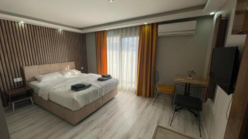 une chambre d'hôtel avec un lit et une télévision dans l'établissement Vero Hotel, à Konak