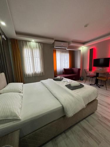 a bedroom with a large bed and a piano at Vero Hotel in Konak