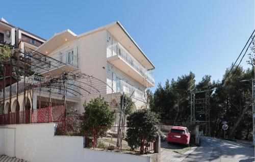 a white house with a car parked in front of it at Beautiful Apartment In Podstrana in Podstrana