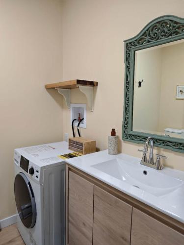 a bathroom with a washing machine and a sink at sweet home in Richmond