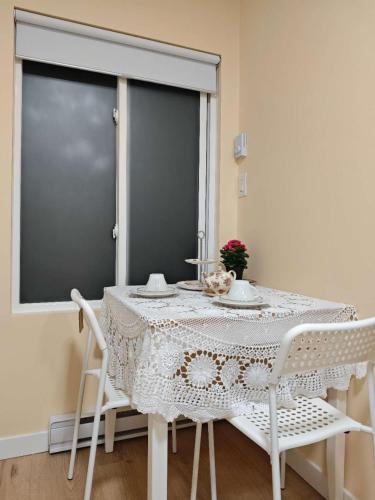 a white table with white chairs and a window at sweet home in Richmond