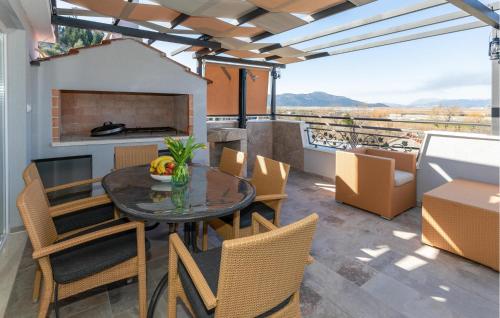a patio with a table and chairs and a fireplace at 3 Bedroom Awesome Home In Mliniste in Mlinište