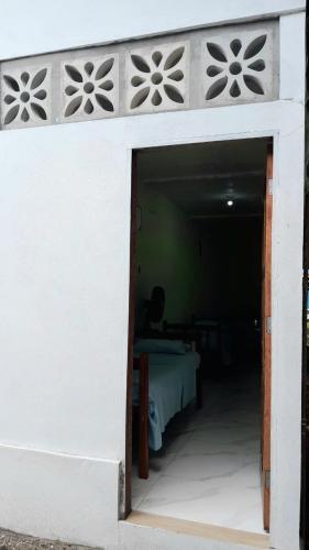 een wit gebouw met een kamer met een bed erin bij Pousada Raio de Sol - Ilha de Itaparica- Catu á 150 m da praia in Vera Cruz de Itaparica