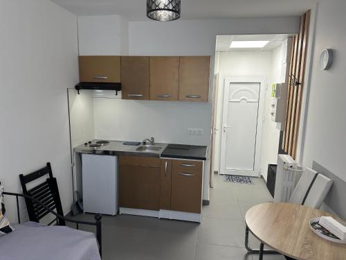 une petite cuisine avec un évier et une table dans l'établissement Studio TenStar, à Aubervilliers