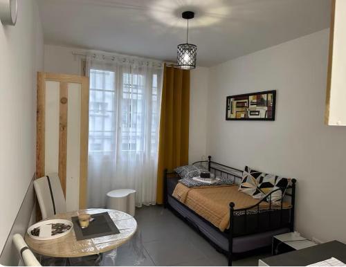 une chambre avec un lit et une table dans une pièce dans l'établissement Studio TenStar, à Aubervilliers