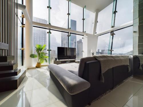 a living room with a couch and large windows at Amazing Skyline Views 3BR Duplex With Free Parking in Manchester