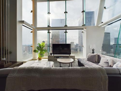 a living room with a couch and a large window at Amazing Skyline Views 3BR Duplex With Free Parking in Manchester