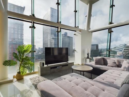 a large living room with large windows and a flat screen tv at Amazing Skyline Views 3BR Duplex With Free Parking in Manchester