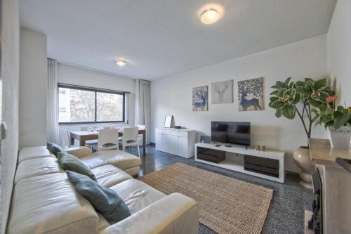 a living room with a white couch and a television at Pontinha Typical by Homing in Lisbon