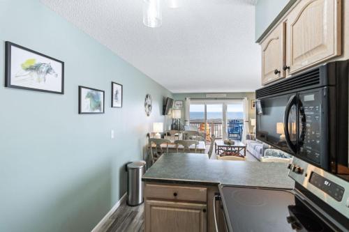 a kitchen with a microwave and a living room at Daze Aaah View in Duck