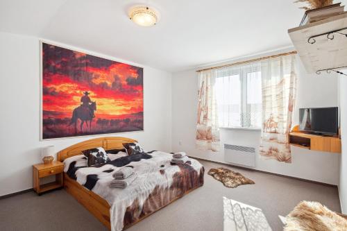 a bedroom with a bed and a painting on the wall at Penzion U Bizona in Cunkov