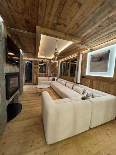 - un salon avec des canapés blancs et une cheminée dans l'établissement Chalet Braconnier, à Montvalezan