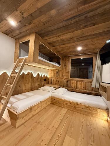 une chambre avec deux lits superposés et une échelle dans l'établissement Chalet Braconnier, à Montvalezan