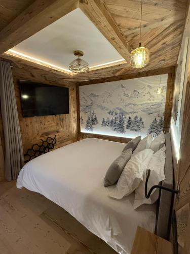 - une chambre avec un lit blanc dans un mur en bois dans l'établissement Chalet Braconnier, à Montvalezan