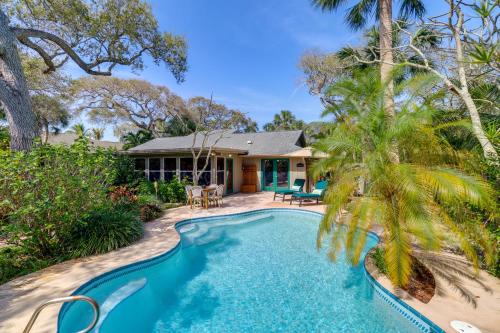 a swimming pool in front of a house with a palm tree at Half-Mi to Private Beach Floridana Beach Getaway in Melbourne Beach