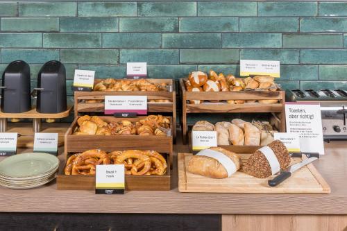 a display of different types of bread and pastries at Candlewood Suites Augsburg in Augsburg