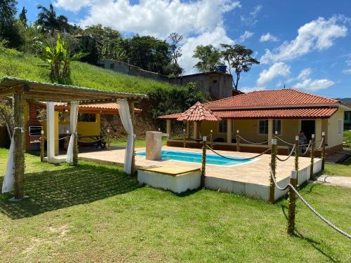 a villa with a swimming pool and a house at Excelente casa com piscina próximo SP in Nazaré Paulista