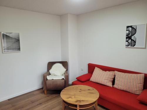 a living room with a red couch and a table at TinyWohnung im Pott in Castrop-Rauxel