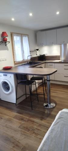 a kitchen with a table and a washing machine at Améthyste in Val-des-Prés