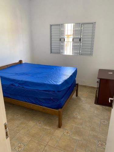 a bedroom with a bed with a blue sheet on it at Excelente casa com piscina próximo SP in Nazaré Paulista