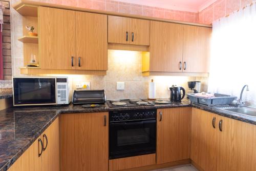 a kitchen with wooden cabinets and a stove top oven at Villa Majestic for Exclusive Accommodation in Port Alfred
