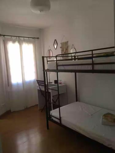 une chambre avec deux lits superposés et une fenêtre dans l'établissement appartement coquet dans maison de village, à Cargèse