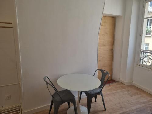 une table et des chaises dans une pièce avec une fenêtre dans l'établissement Chambre privée - Vue Tour Eiffel, à Paris