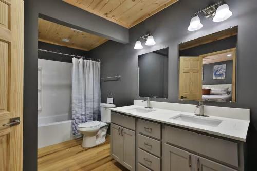 a bathroom with two sinks and a toilet and a mirror at New listing-- Hocking Hills Modern Cabin in Logan