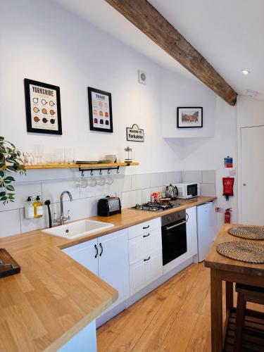 a kitchen with white cabinets and a counter top at Nine Cooper Lane, Holmfirth in Holmfirth