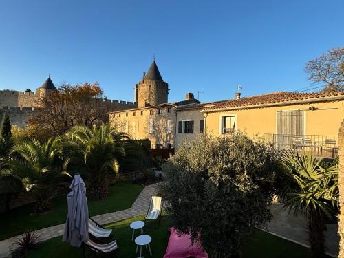 Elle offre une vue sur un jardin avec un château en arrière-plan. dans l'établissement La Vade, à Carcassonne