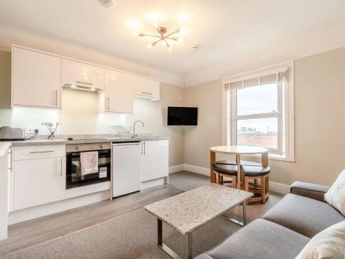 a kitchen and living room with a couch and a table at Sea View Apartment Near The Beach and Town Center in Cromer