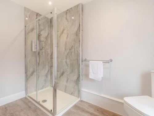 a shower with a glass door in a bathroom at Sea View Apartment Near The Beach and Town Center in Cromer