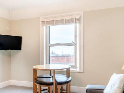 a living room with a table and a window at Sea View Apartment Near The Beach and Town Center in Cromer