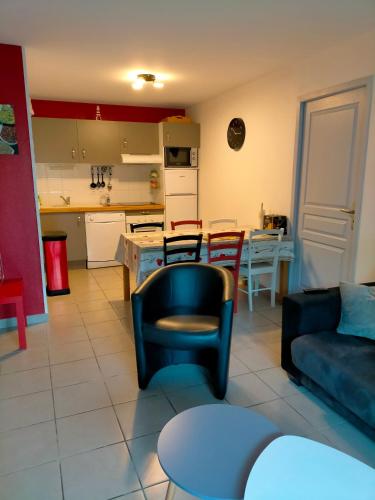 un salon avec un canapé et une cuisine dans l'établissement Bel appartement Narbonne plage, à Narbonne-Plage