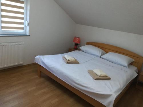 a bedroom with a bed with two towels on it at Villa Aida in Bihać