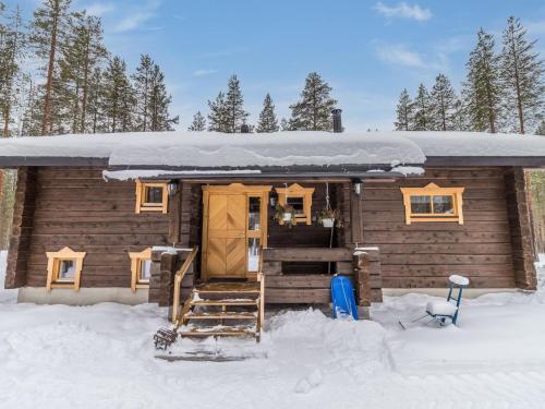 eine Holzhütte mit Schnee auf dem Dach im Schnee in der Unterkunft Holiday Home Juohde by Interhome in Kuusamo