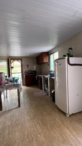 a kitchen with a white refrigerator in a room at Paraíso in Benfica