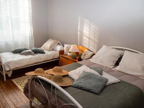 a bedroom with two beds with hats on them at Holiday Home Le Havre de Lage by Interhome in Moissannes
