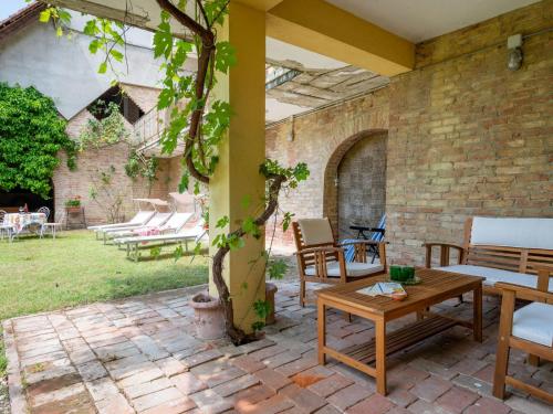 un patio con sillas, una mesa y un árbol en Holiday Home Cascina Calore by Interhome, en Cortiglione