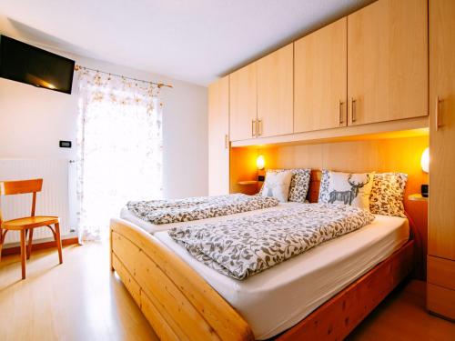 a bedroom with a large bed with wooden cabinets at Apartment Delago by Interhome in Pera
