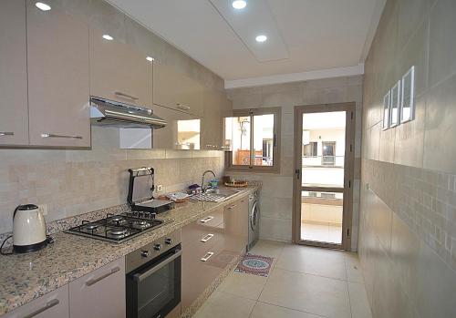 エッサウィラにあるblue perl appartement haut standing luxury servicesのシンクとコンロのあるキッチン トップオーブン