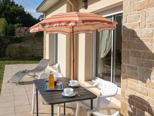 ein Tisch und Stühle unter einem Sonnenschirm auf einer Terrasse in der Unterkunft Apartment Hortensias 1 by Interhome in Clohars-Carnoët